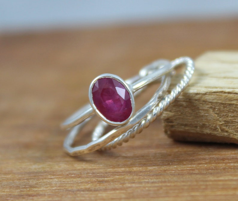 Puede incluir: Un conjunto de tres anillos de plata. El anillo principal presenta un rub&iacute; ovalado de color rojo intenso. Los otros dos anillos tienen dise&ntilde;os &uacute;nicos, uno con una textura de cuerda trenzada y otro con una banda lisa.