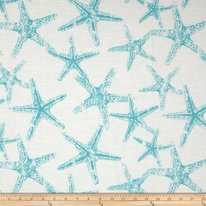 Puede incluir: Tela blanca con un patr&oacute;n repetido de estrellas de mar azul turquesa.