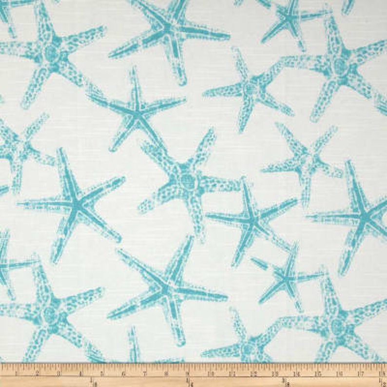 Puede incluir: Tela blanca con un patr&oacute;n repetido de estrellas de mar azul turquesa.