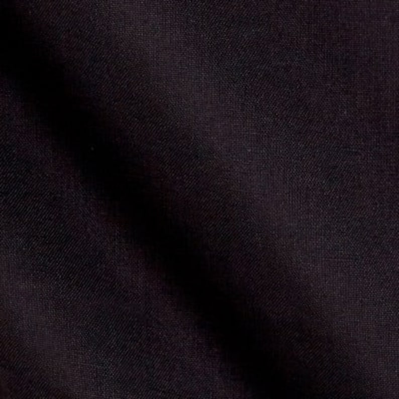 May include: A close-up of a dark black fabric with a smooth, even texture.