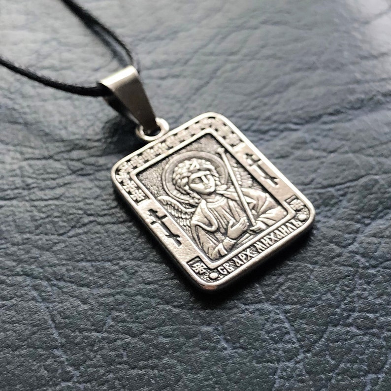 May include: Silver pendant necklace with a rectangular icon of an angel with wings and a halo. The icon has the text "СВ. АРХ. МИХАИЛ" in Cyrillic script.