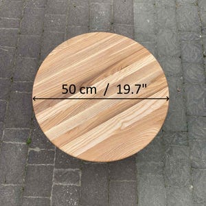 Pode incluir: Um tampo de mesa redondo de madeira clara, com 50 cm de diâmetro. O veio da madeira é visível. O tampo está inacabado e pronto para uso.