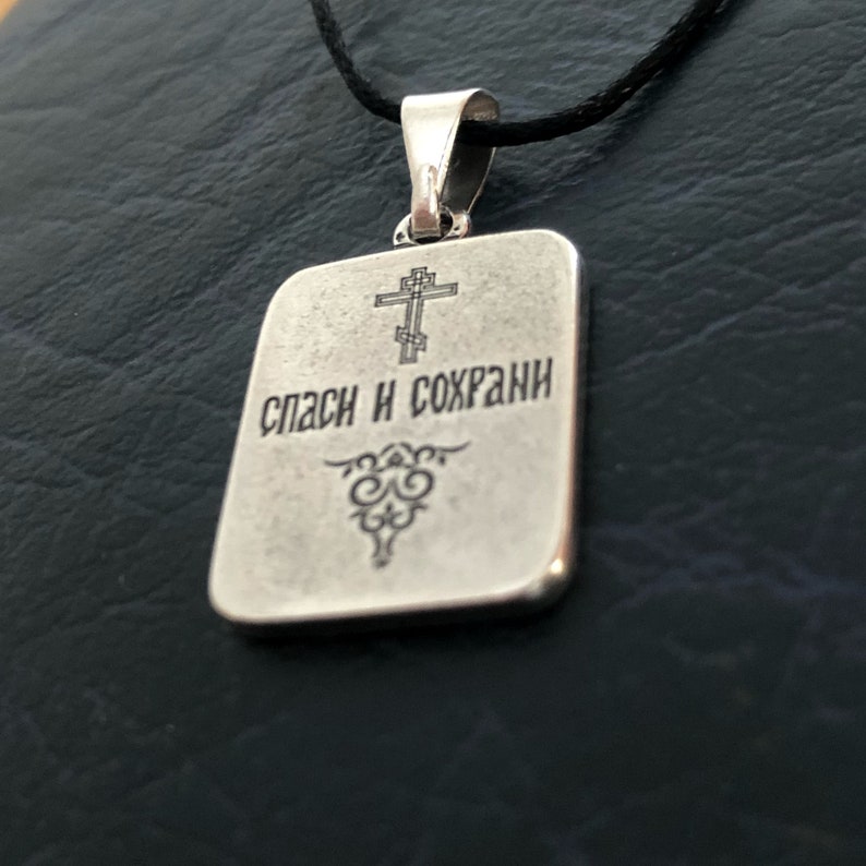 May include: Silver pendant with a cross and the inscription "Спаси и сохрани" (Save and Preserve) in Russian.