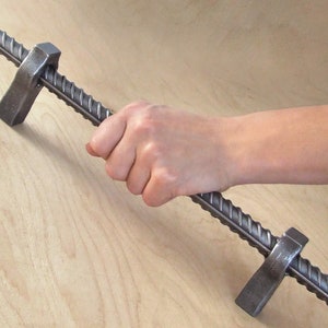 May include: A silver metal door handle with a twisted design. The handle is attached to a wooden surface.