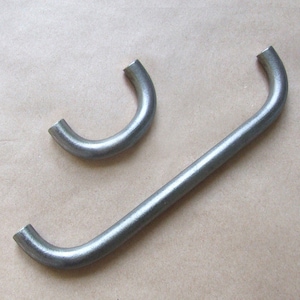 May include: Two metal handles, one is a straight bar with rounded ends and the other is a U-shaped handle.
