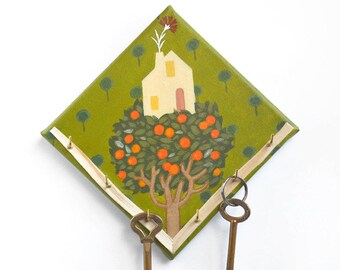 Hand-painted key holder on a mini canvas with a little house on a tree in folk style, ideal as a housewarming gift.