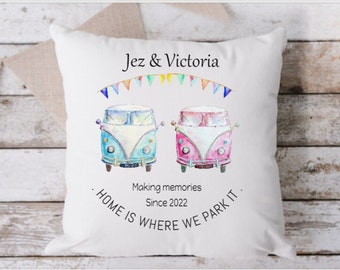 May include: White throw pillow with a watercolor illustration of two vintage camper vans, one blue and one pink, with a string of colorful flags above them. The text "Jez & Victoria Making memories Since 2022 HOME IS WHERE WE PARK IT." is printed below the vans.