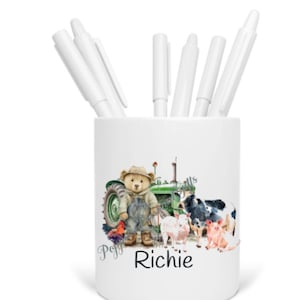 May include: White ceramic pencil holder with a green tractor, a teddy bear, and farm animals. The text "Peggy Richie" is printed on the front.