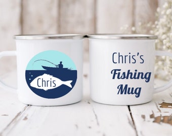 May include: Two white enamel mugs with blue and light blue designs. One mug has a silhouette of a person fishing with a fish and the name "Chris" on it. The other mug says "Chris's Fishing Mug".