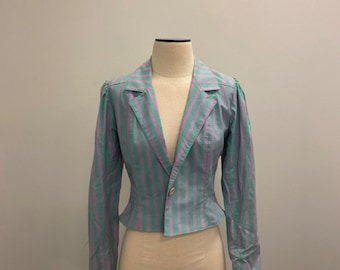 May include: A pastel-colored, striped blazer with a tailored fit. The jacket features vertical stripes in shades of green and purple, a notched collar, and a single-button closure. The sleeves have a slight puff at the shoulders. The blazer is displayed on a mannequin.