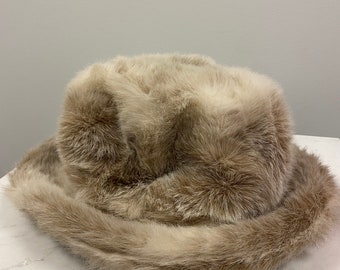May include: A brown faux fur bucket hat with a wide brim.
