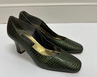 May include: A pair of green snakeskin heeled pumps with a square toe. The shoes have a gold insole and the brand name "Renee" is visible on the insole.