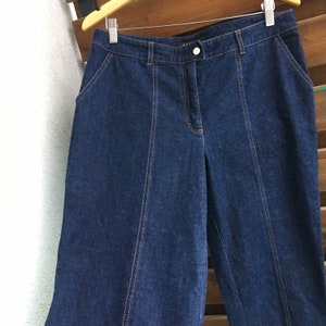 May include: Dark blue denim wide-leg pants with a button closure and a straight leg.