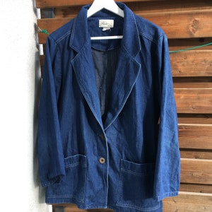 May include: A dark blue denim jacket with a button closure and two pockets. The jacket has a label that reads "Blake."