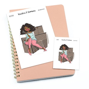 Puede incluir: Una pegatina con una ilustración de dibujos animados de una mujer con cabello castaño sentada encima de cajas de cartón. Ella está sosteniendo un rollo de cinta y unas tijeras. La pegatina tiene el texto "Vaalea & Tumma".