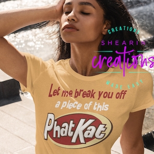 May include: A yellow t-shirt with the text "Let me break you off a piece of this" and a red and white logo that says "Phat Kat".