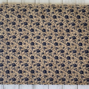 May include: A beige quilted placemat with a navy blue floral pattern.