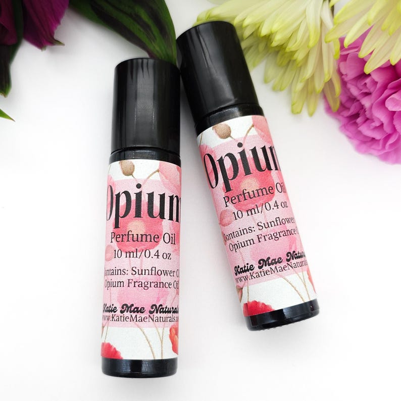 Puede incluir: Dos botellas de aceite de perfume Opium de 10 ml / 0,4 oz. Las botellas tienen tapas negras y etiquetas con dise&ntilde;os florales rosas. Las etiquetas dicen "Opium Perfume Oil" y "Contiene: Aceite de girasol, Aceite de fragancia de opio".