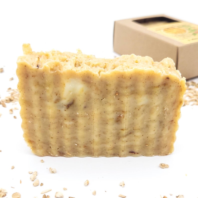 May include: A bar of handmade soap with a light brown colour and a textured surface. The soap is made with oatmeal and has a natural, earthy scent.