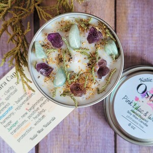 Peut inclure: Une bougie en cire de soja blanche parfum&eacute;e &agrave; la lavande rose et blanche. La bougie est surmont&eacute;e de cristaux verts et violets et de fleurs s&eacute;ch&eacute;es. La bougie est dans un r&eacute;cipient en &eacute;tain avec une &eacute;tiquette qui indique "Katie Ost Pink Lilac & White Hand Poured Soy Wax Candle phthalate free 6 oz".