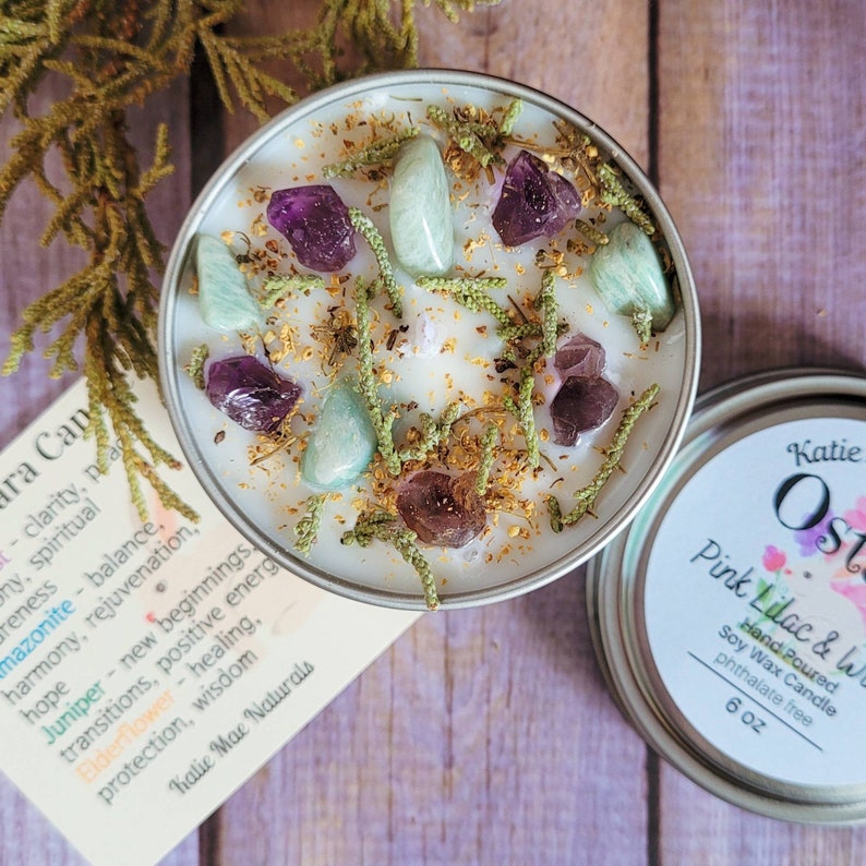 Peut inclure: Une bougie en cire de soja blanche parfum&eacute;e &agrave; la lavande rose et blanche. La bougie est surmont&eacute;e de cristaux verts et violets et de fleurs s&eacute;ch&eacute;es. La bougie est dans un r&eacute;cipient en &eacute;tain avec une &eacute;tiquette qui indique "Katie Ost Pink Lilac & White Hand Poured Soy Wax Candle phthalate free 6 oz".