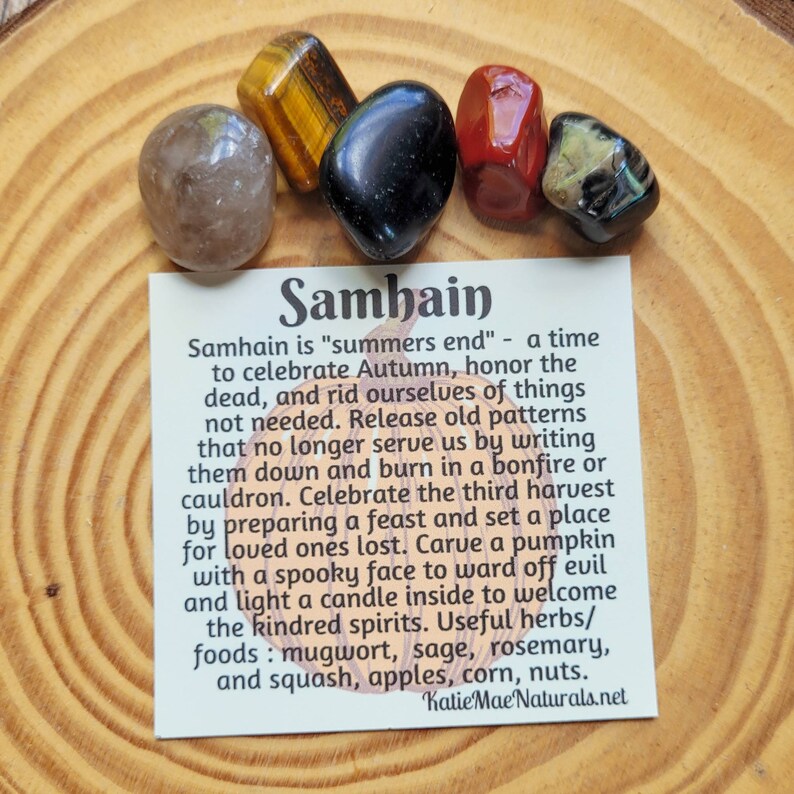 May include: A card with the word "Samhain" written in large, bold letters. The card explains the meaning of Samhain, a Celtic holiday celebrating the end of summer and the beginning of autumn. The card also lists herbs and foods associated with the holiday, such as mugwort, sage, rosemary, squash, apples, corn, and nuts.