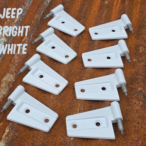 May include: Eight bright white Jeep door hinges with a tapered shape and two mounting holes each. The metal hinges feature a cylindrical barrel with a protruding pin. The text JEEP BRIGHT WHITE is visible in the upper left corner of the image.