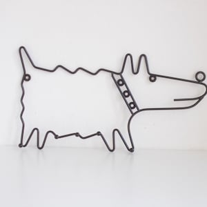 Könnte beinhalten: Eine schwarze Drahtskulptur eines Hundes mit Halsband. Der Hund blickt nach rechts und hat ein einfaches, cartoonartiges Design.