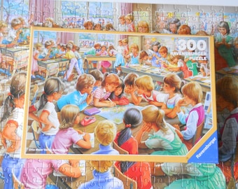 May include: A 300-piece Ravensburger puzzle featuring a classroom scene with children. The image shows a group of children gathered around a table, studying a map. The puzzle is surrounded by other puzzle pieces, creating a border.