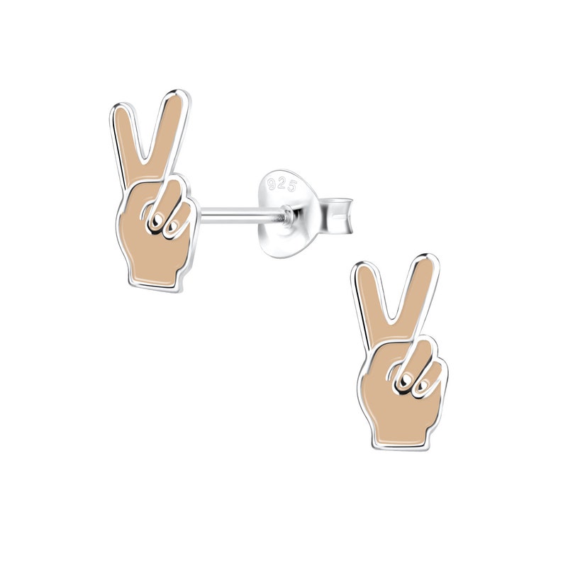 May include: A pair of silver peace sign earrings with a beige enamel finish. The earrings are in the shape of a hand making the peace sign.