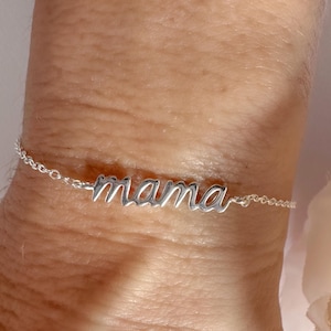 May include: A silver bracelet with the word "mama" spelled out in cursive.
