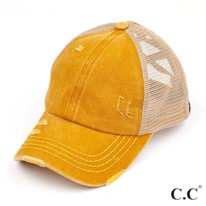 May include: Mustard yellow baseball cap with a distressed finish. The cap has a mesh back, a curved peak, and embroidered details. It features a button on top and the brand name "C.C." on the side.