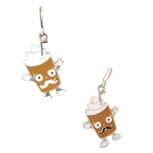May include: A pair of dangle earrings featuring a cartoon coffee cup with a white lid, brown coffee, a straw, and a smiling face with a moustache. The coffee cup has arms and legs.