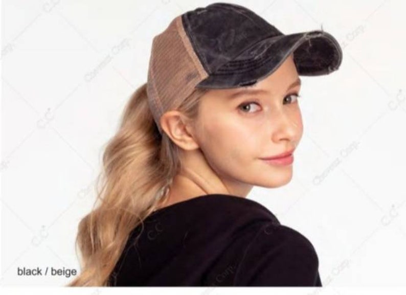 May include: Black and beige distressed baseball cap with a mesh back. The cap has a curved brim and a worn appearance. The text "black / beige" is visible in the lower left corner.