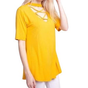 May include: Mustard yellow short-sleeve top with a criss-cross neckline. The top has a V-neck and a relaxed fit. The fabric appears to be a soft, lightweight material. The top is a solid color and has a simple, yet stylish design.