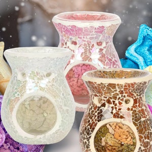 Peut inclure: Trois diffuseurs d'huiles en verre mosaïque en blanc, rose et marron. Les diffuseurs ont la forme d'un vase avec une large ouverture en haut. Les diffuseurs sont entourés de galets de cire décoratifs de différentes couleurs et formes.