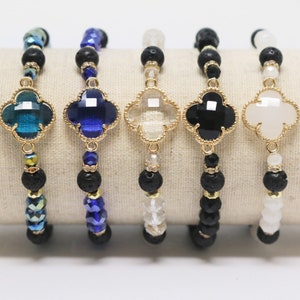 May include: Five bracelets with different colored four-leaf clover charms. Each bracelet has black lava rock beads and crystal beads in various colors.
