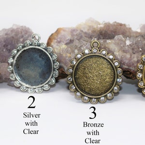 May include: Four round metal pendant trays with clear rhinestone borders. The trays are in gunmetal, silver, bronze, and gold.