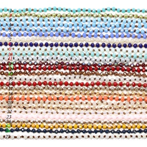 May include: Twenty-seven strands of faceted glass beads in various colors, including turquoise, blue, white, red, orange, and yellow. The beads are strung on a thin cord.
