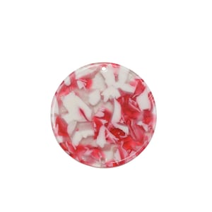 May include: A round, white and red marbled plastic pendant with a hole at the top for hanging.
