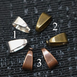 Op de afbeelding: Vijf verschillende metalen sluitingen, genummerd van 1 tot 3, in zilver, messing en koper.