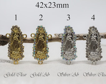 Puede incluir: Cuatro abalorios de plata y oro con una imagen de la Virgen María con cristales transparentes e iridiscentes. Los abalorios miden 42 mm x 23 mm y tienen dos anillos de salto para sujetarlos a joyas.