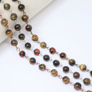 May include: Three strands of brown tiger's eye beads with silver, copper, and gold chain links.