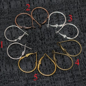 May include: Five pairs of hoop earrings in different sizes and finishes. The earrings are numbered 1 through 5. The earrings are silver, gold, and bronze.