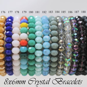 May include: A set of 15 bracelets made with 8mm crystal beads in various colors, including orange, blue, white, turquoise, light blue, gray, silver, black, and iridescent. The bracelets are numbered 175 through 189.