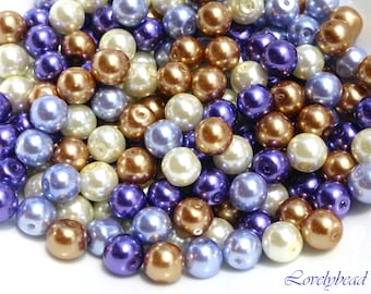 May include: A collection of pearl beads in shades of ivory, light blue, and purple. The beads are round and have a smooth, glossy finish.