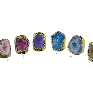 May include: Eight gold rings with different colored agate stones. The rings are numbered 1 through 8.