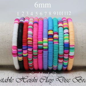 May include: Twelve colorful adjustable bracelets made with 6mm clay heishi beads. The bracelets are stacked on top of each other and are made in a variety of colors, including pink, blue, green, yellow, and red.
