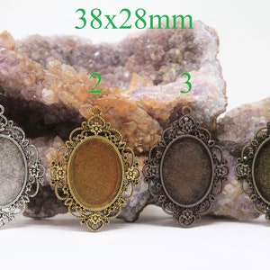 May include: Four oval-shaped metal pendant trays with ornate filigree designs. The trays are 38x28mm and come in silver, gold, bronze, and antique brass.