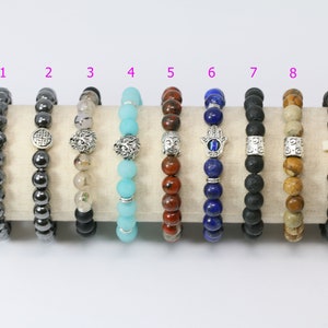 Pode incluir: Nove pulseiras de contas com vários designs e cores. As pulseiras incluem hematita facetada, detalhes prateados, contas turquesas e pedra de lava. Algumas pulseiras apresentam amuletos de Buda, Hamsa e cruz.